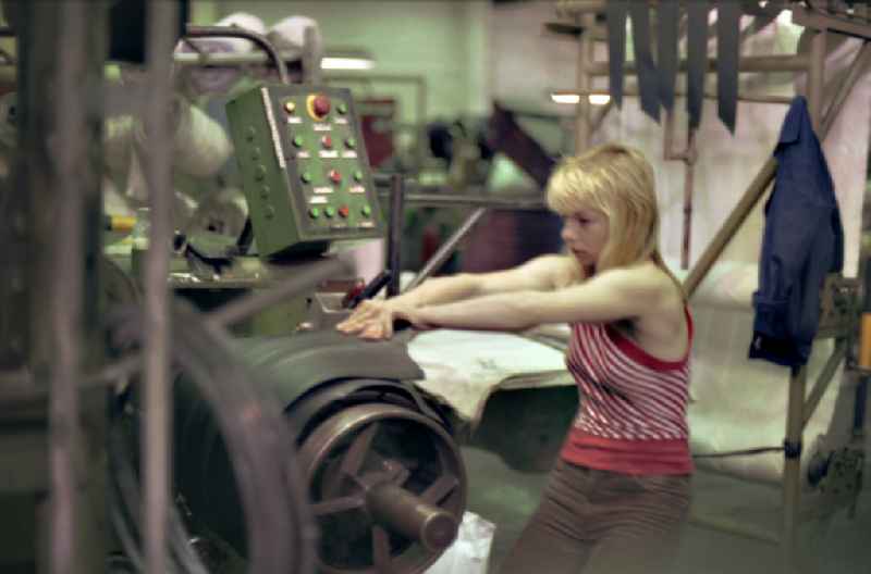 Young woman as a worker at work and factory equipment for tire production in the VEB tire factory on Ihlenfelder Strasse in Neubrandenburg in the state of Mecklenburg-Western Pomerania on the territory of the former GDR, German democratic republic