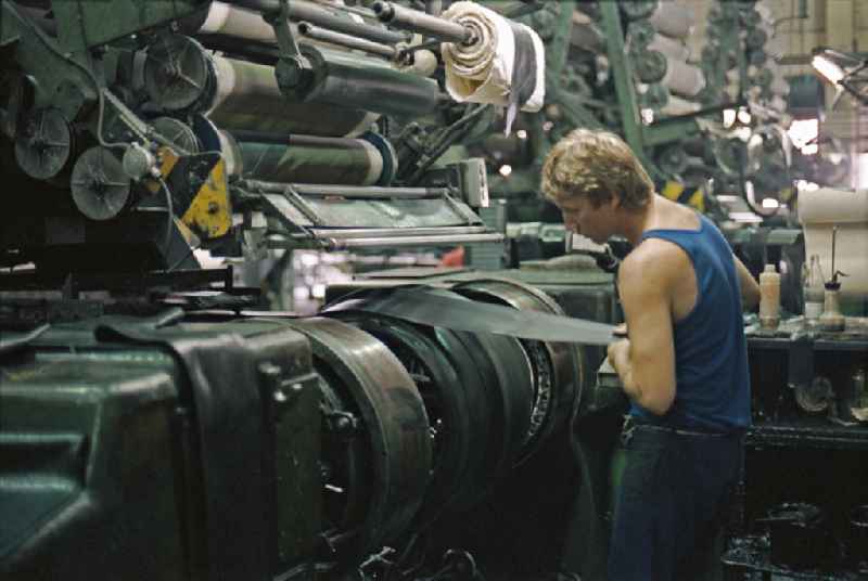 Young woman as a worker at work and factory equipment for tire production in the VEB tire factory on Ihlenfelder Strasse in Neubrandenburg, of Mecklenburg-Western Pomerania on the territory of the former GDR, German democratic republic