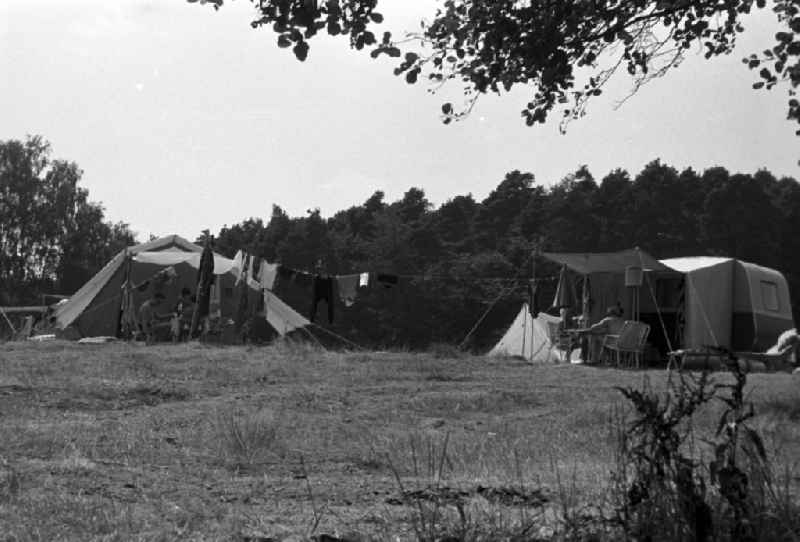 Two campers from their tents in Brandenburg. In between a clothesline was stretched. Family camping holidays at Rottstielfließ on Tornowsee in Brandenburg