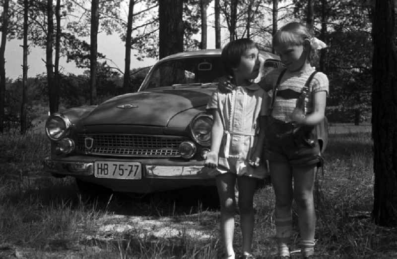 Two girls standing in front of a Wartburg 311 in a forest in Brandenburg