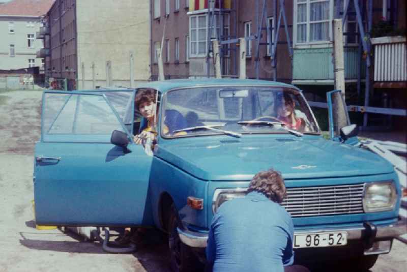 A family cleans their blue Wartburg 353 in Neustrelitz in Mecklenburg-Vorpommern on the territory of the former GDR, German Democratic Republic