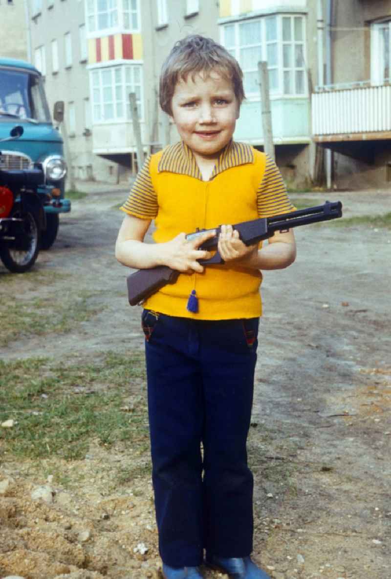 Boy with toys gun in Neustrelitz in the federal state Mecklenburg-West Pomerania in the area of the former GDR, German democratic republic