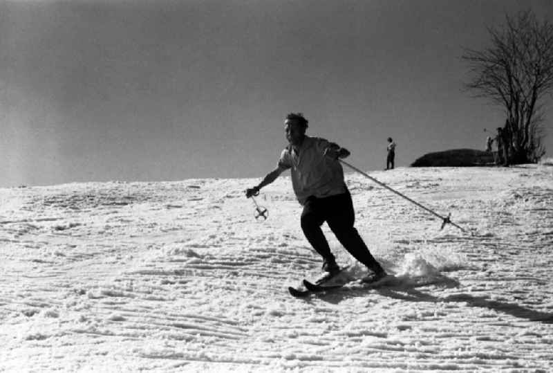 Skiers on a snow-covered slope on the Fichtelberg mountain in Oberwiesenthal in the state Saxony on the territory of the former GDR, German Democratic Republic
