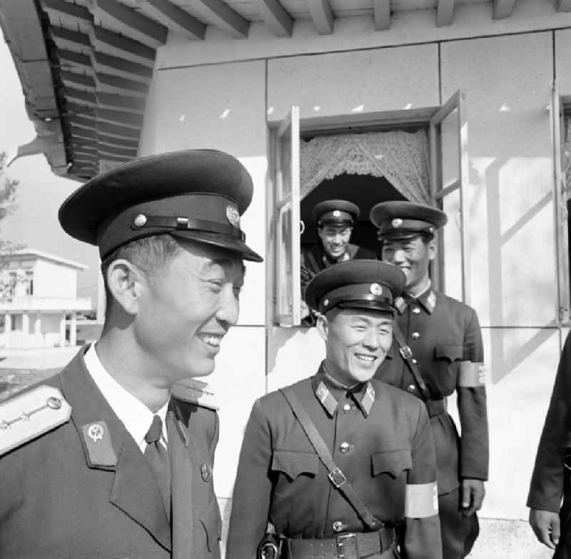 Nordkoreanische Offiziere in Panmunjeom (auch Joint Security Area JSA genannt). Panmunjeom ist eine militärische Siedlung in der entmilitarisierten Zone zwischen Nord- und Südkorea und seit dem Waffenstillstandsabkommen 1953 das Hauptquartier der Military Armistice Commission (MAC), die die Einhaltung des Waffenstillstands überwacht. Seit den Gesprächen des Waffenstillstandskomitees des Roten Kreuzes im Herbst 1971 wurden in Panmunjeom Gespräche zwischen Nord- und Südkorea geführt, wobei vor allem das Thema der Familienzusammenführungen bzw. -treffen im Mittelpunkt stand. Es ist die einzige zollähnliche 'offene' Grenzstelle, wo ohne Grenzübertretung am selben Tisch Verhandlungen und Gespräche stattfinden konnten.