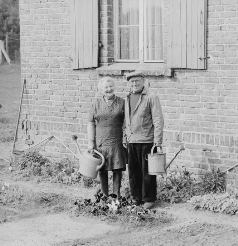 Mature couple with watering can in her garden in Pasewalk in today's State of Mecklenburg-Western Pomerania