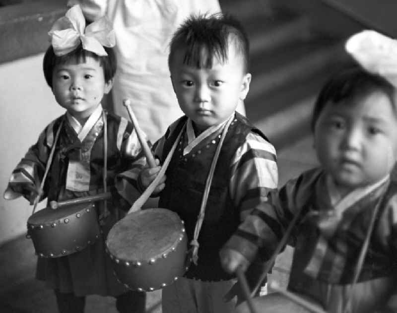 In einem Kindergarten in Pjöngjang, der Hauptstadt der Koreanischen Demokratischen Volksrepublik KDVR - Nordkorea / Democratic People's Republic of Korea DPRK - North Korea, trommeln kleine Kinder auf ihren umgehängten Trommeln.