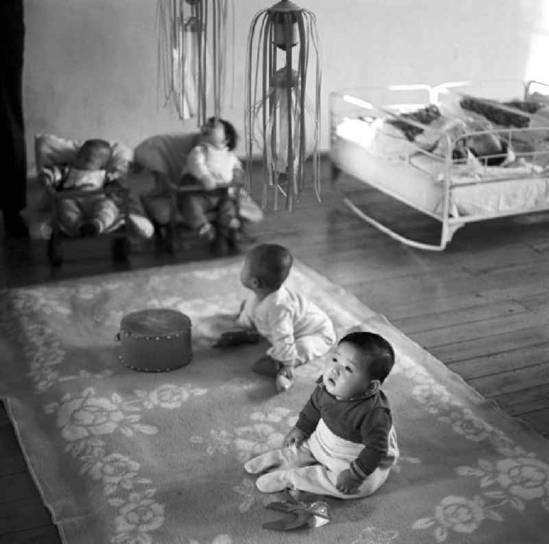 Alltag in einem Kindergarten in Pjöngjang, der Hauptstadt der Koreanischen Demokratischen Volksrepublik KDVR - Nordkorea / Democratic People's Republic of Korea DPRK - North Korea. Über Babys hängen zur 'Beschäftigung' Mobiles.