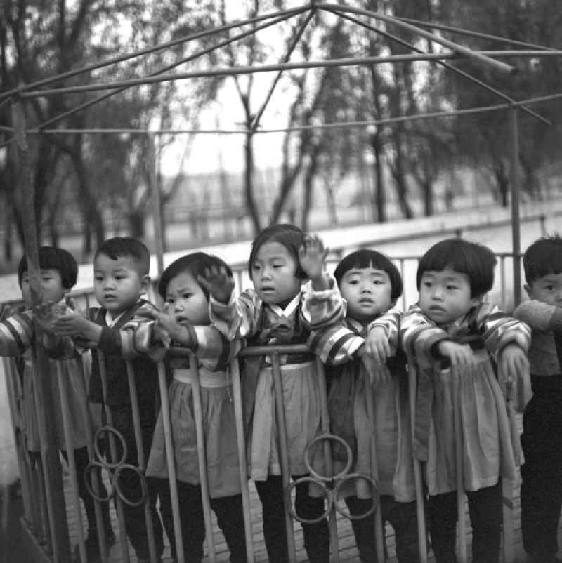 Kinder stehen in einem Karussell auf dem Spielplatz in einem Kindergarten in Pjöngjang, der Hauptstadt der Koreanischen Demokratischen Volksrepublik KDVR - Nordkorea / Democratic People's Republic of Korea DPRK - North Korea.