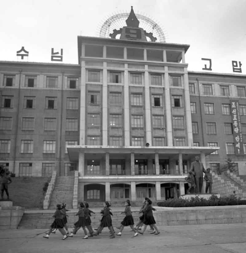Eine Mädchengruppe in Uniform marschiert vor dem Pionierpalast in Pjöngjang, der Hauptstadt der Koreanischen Demokratischen Volksrepublik KDVR - Nordkorea / Democratic People's Republic of Korea DPRK - North Korea.