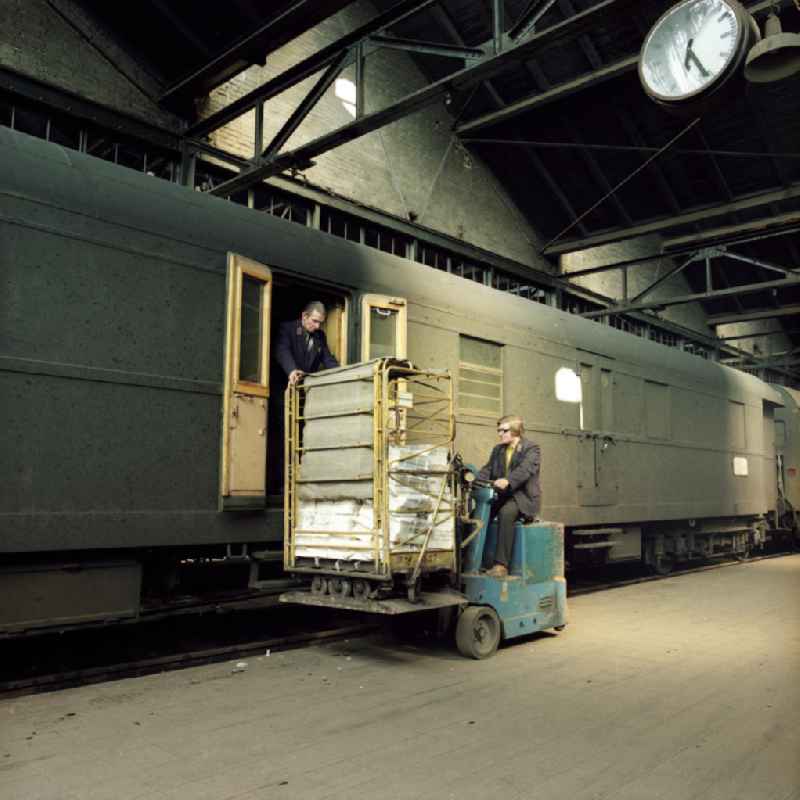 Postmitarbeiter verladen Postsendungen am Posteisenbahnwagen im Güterbahnhof Potdam Stadt (heute Hauptbahnhof).