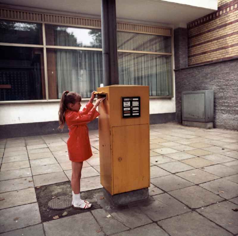Ein Mädchen wirft einen Brief in den Briefkasten vor einer Filiale in Potsdam Babelsberg.