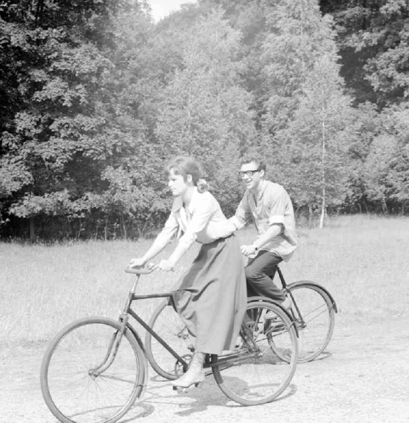 The actor Angelica Domroese and Jaecki Black cycling in Potsdam in Brandenburg on the territory of the former GDR, German Democratic Republic. Here shooting at the DEFA to the 5- part television series 'Krupp and Krause' in Sanssouci