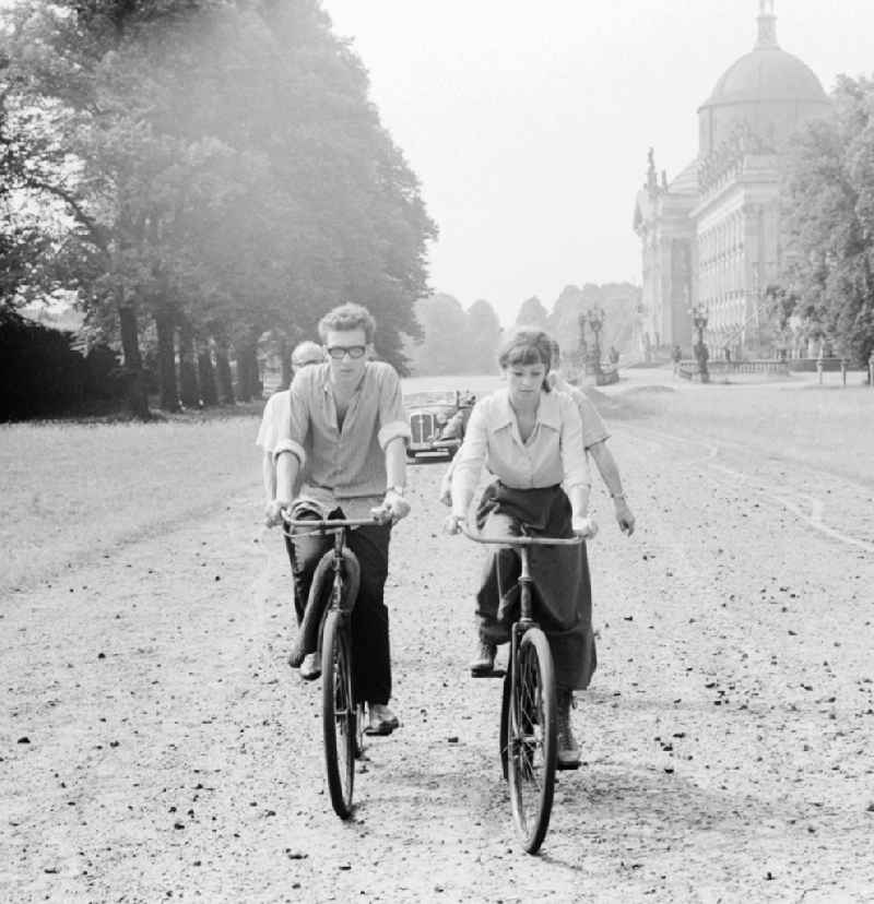 The actor Angelica Domroese and Jaecki Black cycling in Potsdam in Brandenburg on the territory of the former GDR, German Democratic Republic. Here shooting at the DEFA to the 5- part television series 'Krupp and Krause' in Sanssouci