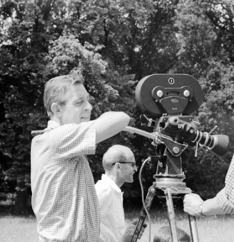 Cameraman with a ARRIFLEX SLR film camera with film shooting in the park at Sanssouci in Potsdam in Brandenburg on the territory of the former GDR, German Democratic Republic