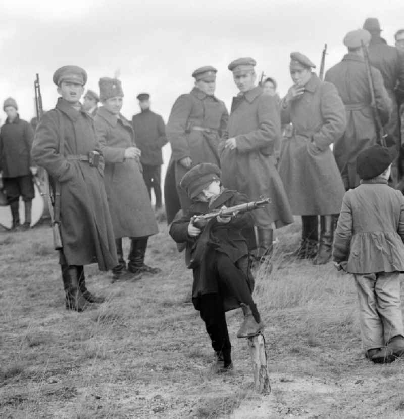 Child play with a gun during the shooting of the feature film 'En Route to Lenin' in Potsdam in Brandenburg on the territory of the former GDR, German Democratic Republic. Filmed in black and white film was produced on the occasion of the 10