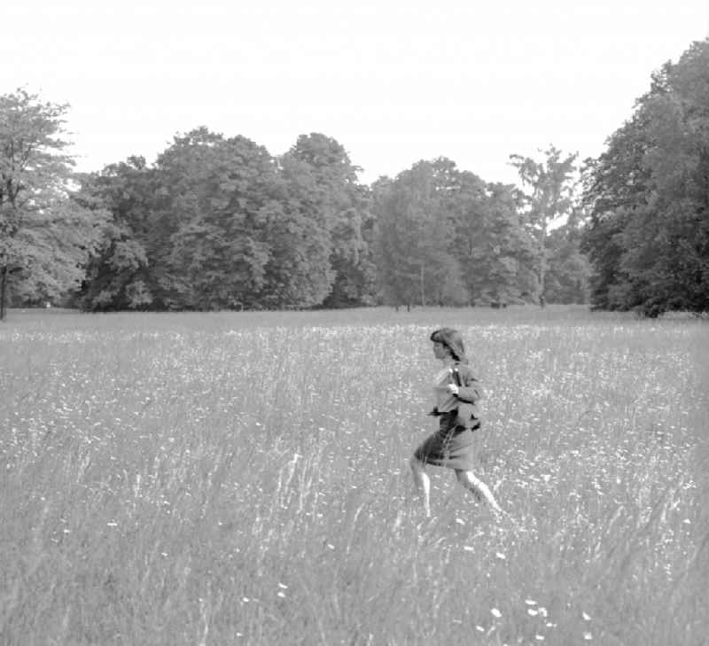 A young woman runs across a meadow in Potsdam in the federal state of Brandenburg on the territory of the former GDR, the German Democratic Republic