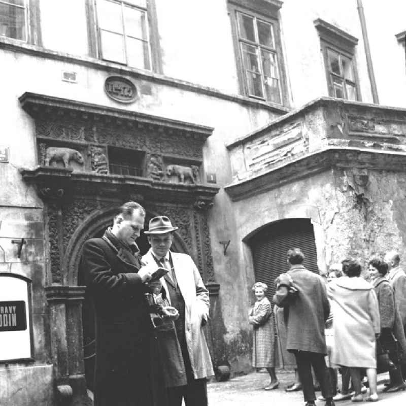 Touristengruppe bei Stadtbesichtigung / Sightseeing in Prag (Praha), Hauptstadt der Tschechoslowakei CSSR (heute Tschechien). Touristen stehen vor Fassade / Hausfassade.