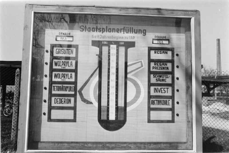 Ideologically oriented slogan and sign for the fulfillment of the state plan with a list of various chemicals and products of chemical production on Grisutenstrasse in Premnitz, Brandenburg in the area of the former GDR, German Democratic Republic
