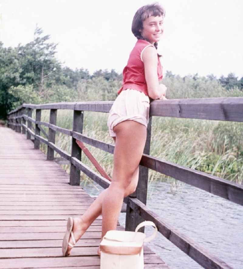 Young girl in to a footbridge on the Baltic Sea in Prerow in the federal state Mecklenburg-West Pomerania in the area of the former GDR, German democratic republic