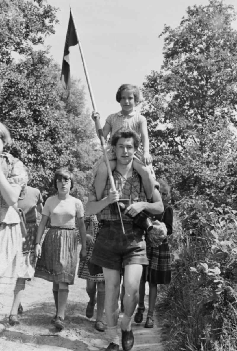 Group of children and teenagers hiking with the pennant youth organization's pennant in Prerow in the state Mecklenburg-Western Pomerania on the territory of the former GDR, German Democratic Republic