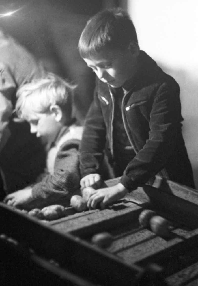 Zwei Schüler bzw. Kinder an einem Band / Sortiermaschine bei der Kartoffelernte im Rahmen von einem Arbeitseinsatz. Zu DDR-Zeiten war es üblich, dass Schüler, Studenten und Arbeiter die Landwirtschaft unterstützen, um fehlende Arbeitskräfte und moderne Technik zu ersetzen. Bestmögliche Qualität nach Vorlage!