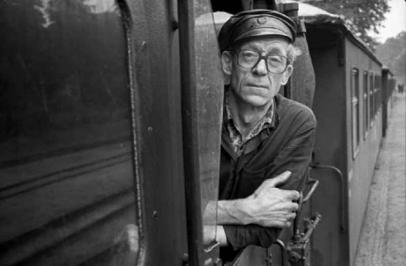 Engine driver in the driver's cab of the train on the station grounds of the Deutsche Reichsbahn narrow-gauge railway in Putbus, Mecklenburg-Western Pomerania in the territory of the former GDR, German Democratic Republic