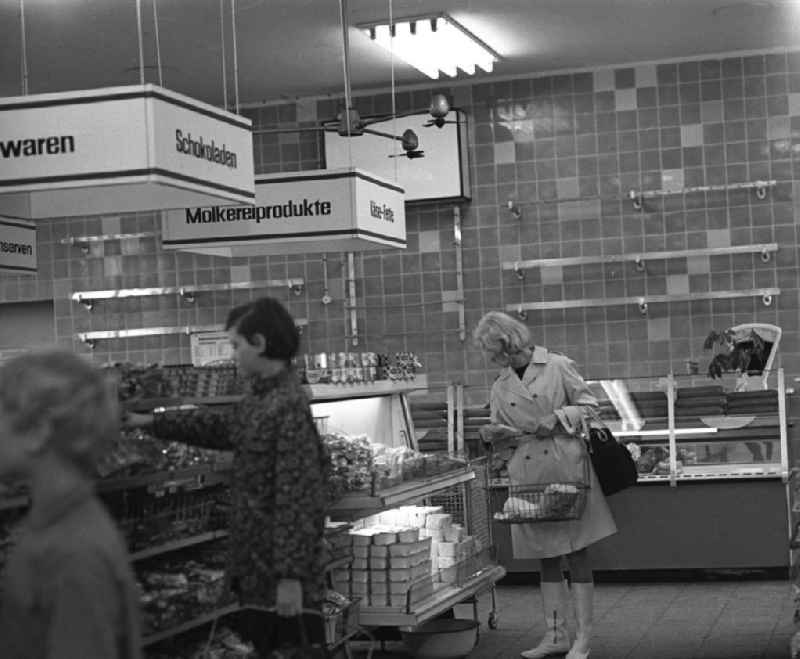 Kundin vor einem Regal mit Molkereiprodukten und Kind vor Süßigkeitenregal der HO Kaufhalle im Ortsteil Lütten Klein in Rostock. Eröffnung am 04.