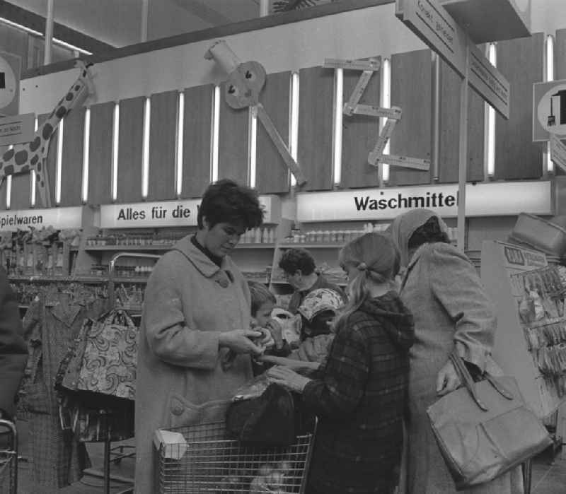Kunden bei der Warenauswahl in der HO Kaufhalle im Ortsteil Lütten Klein in Rostock. Im Hintergrund Auslagen mit Waschmitteln und Spielwaren. Eröffnung am 04.