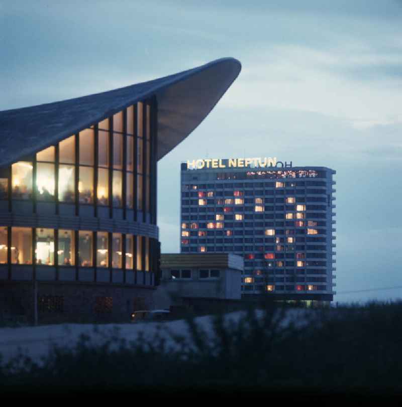 Blick auf die Wahrzeichen von Warnemünde in der Abenddämmerung - der sogenannte 'Teepott' und das Hotel Neptun. Der sogenannte Teepott wurde 1967 nach den Plänen des Architekten U. Müther erbaut.