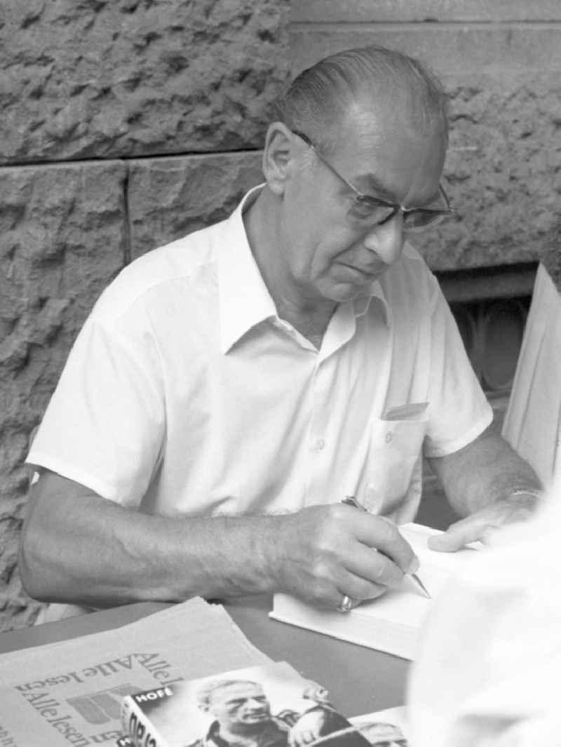 Der Schriftsteller Günter Hofé ( Pseudonym: Bernd Elberger ) signiert ein Buch auf dem Schriftstellerbasar in Rostock.
