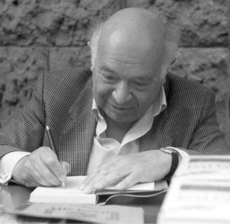 Der deutsch-jüdische Schriftsteller Rudolf Hirsch signiert ein Buch auf dem Schriftstellerbasar in Rostock.
