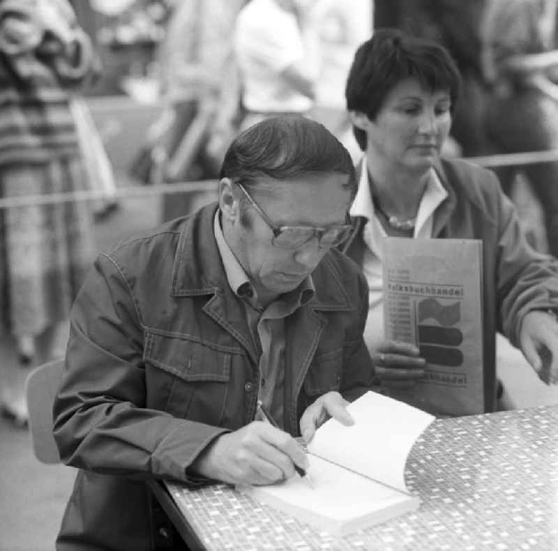 Der Schriftsteller Klaus Möckel signiert sein Buch auf dem Schriftstellerbasar in Rostock.