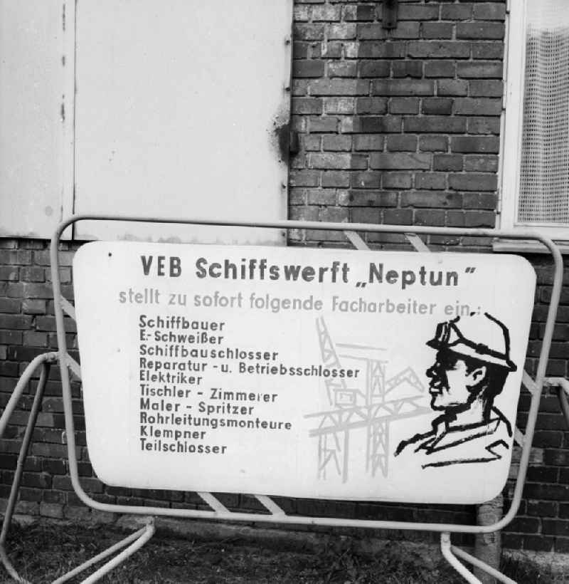 Sign of the dockyard VEB Neptune about open jobs in Rostock in the federal state Mecklenburg-West Pomerania in the area of the former GDR, German democratic republic. Searched to the immediate setting in the production skilled workers become welders, shipbuilding locksmiths, repair and company locksmiths, electricians, joiners - carpenter, painter - splash, conduit assemblers, plumbers and part locksmiths as a shipwright
