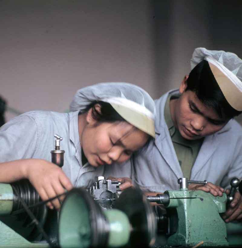 Vietnamesische Praktikanten arbeiten an einem Schraubstock bei der Ausbildung im Zweigbetrieb Saalfeld des VEB Carl Zeiss Jena. Vietnamesen bildeten in der DDR die größte Gruppe an Arbeitskräften aus den sozialistischen Bruderländern.