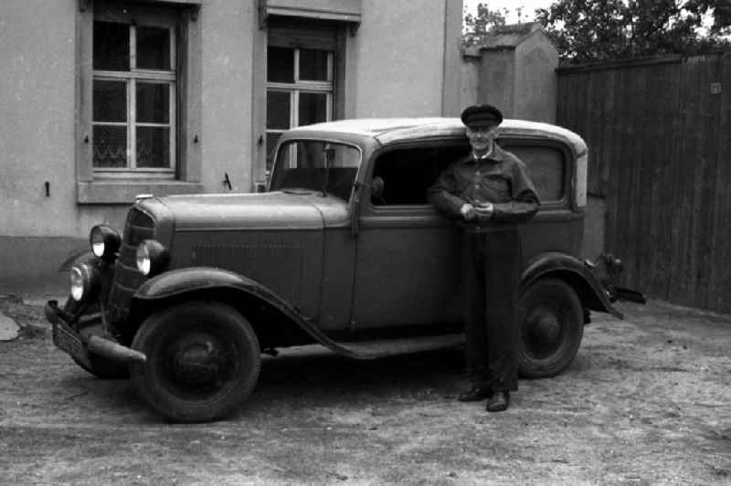 A man by an Opel P4 convertible saloon in outwash plain village-Brehna in the federal state Saxony-Anhalt in Germany