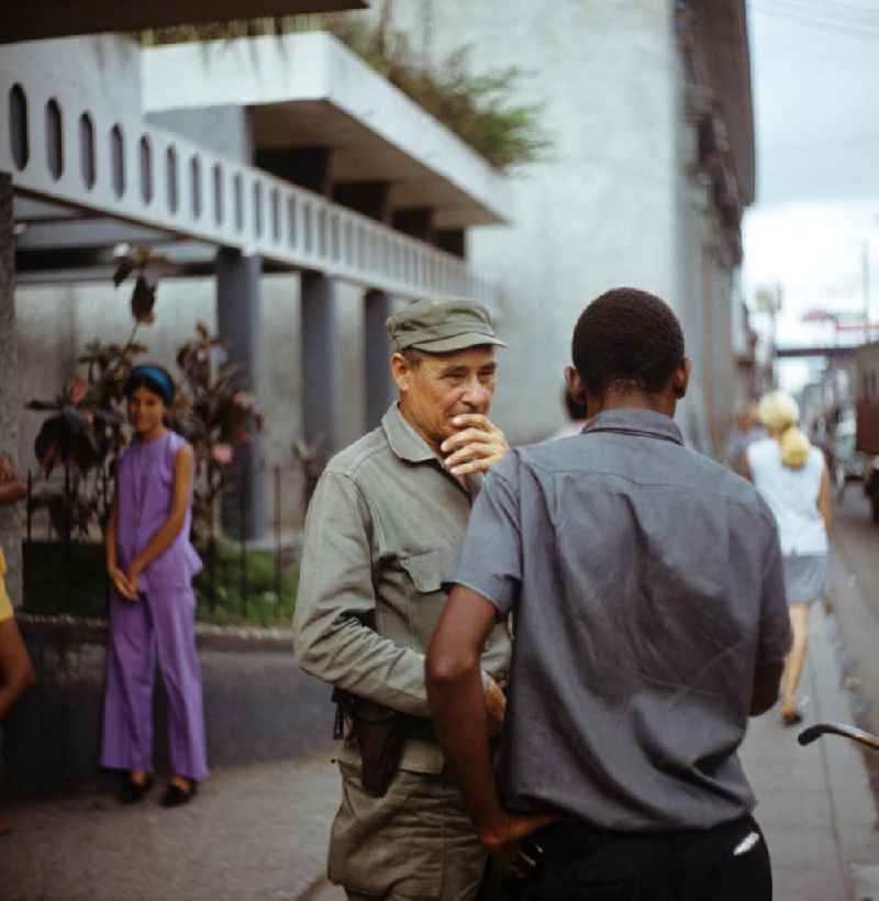 Straßenszene in Santa Clara in Kuba. Ein kubanischer Soldat im Gespräch. Street scene in Santa Clara - Cuba. A Cuban soldier in conversation.