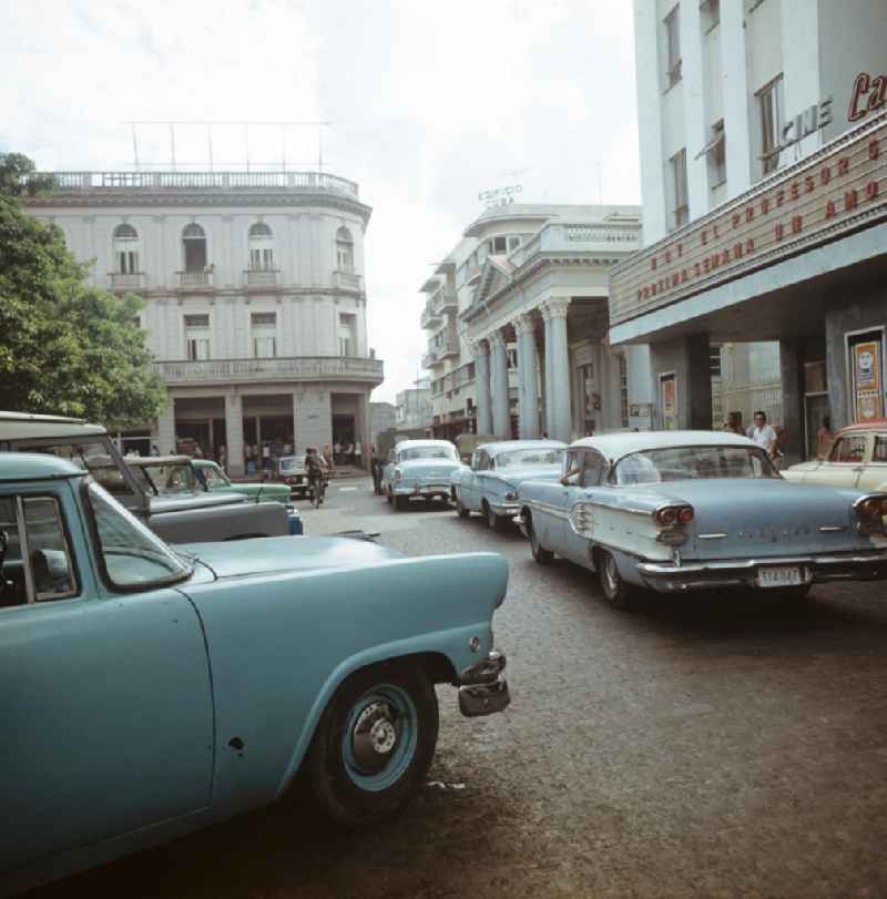 Straßenszene in Santa Clara am Parque Vidal, dem zentralen Platz der Stadt, mit Kino (r) und historischen Gebäuden. Street scene in Santa Clara - Cuba.