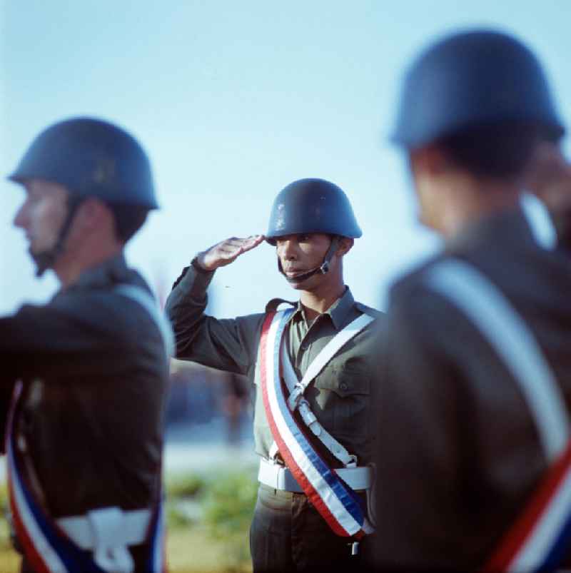 Aufstellung der kubanischen Ehrengarde zu Ehren des offiziellen Besuches des Staats- und Parteivorsitzenden der DDR, Erich Honecker, auf dem Flughafen Santiago de Cuba - Soldaten mit Schärpe in den kubanischen Nationalfarben salutieren. Honecker stattete vom 2