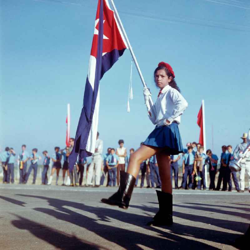 Ein junges Pioniermädchen präsentiert zur Ankunft des Staats- und Parteivorsitzenden der DDR, Erich Honecker, auf dem Flughafen Santiago de Cuba die kubanische Flagge. Honecker stattete vom 2