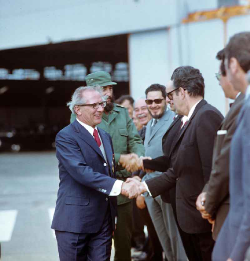 Der Staats- und Parteivorsitzende der DDR, Erich Honecker, wird auf dem Flughafen Santiago de Cuba von dem kubanischen Regierungschef Fidel Castro und weiteren Regierungsvertretern in Empfang genommen. Honecker stattete vom 2