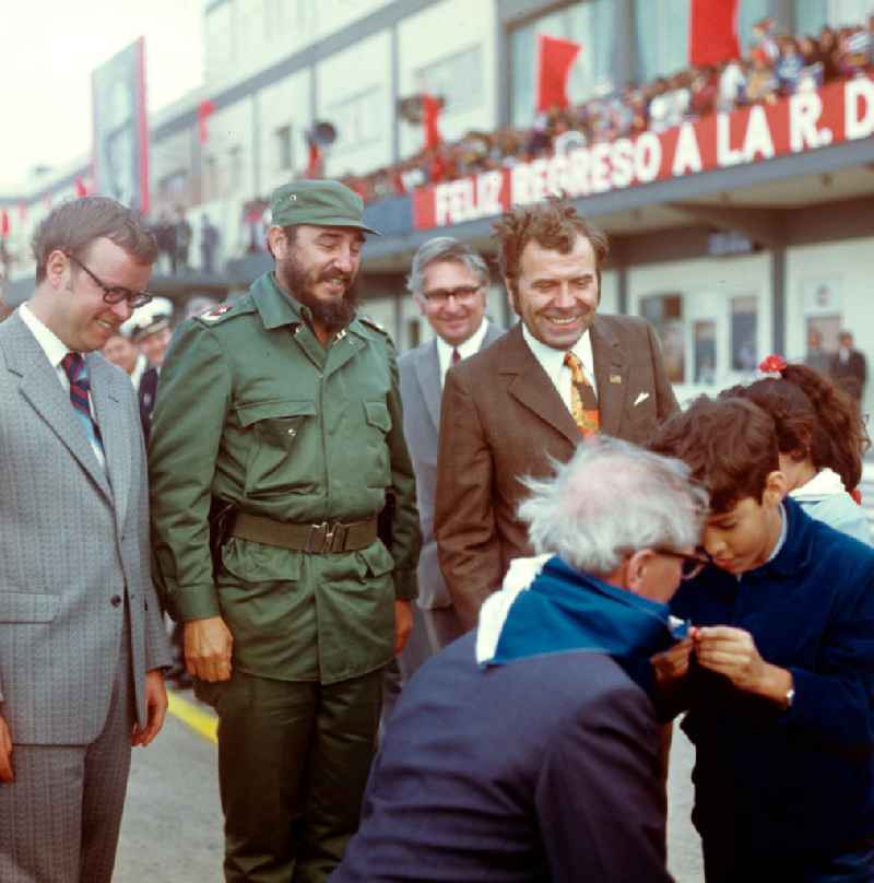 Ein kubanischer Pionier bindet dem Staats- und Parteivorsitzenden der DDR, Erich Honecker, bei dessen Ankunft auf dem Flughafen Santiago de Cuba ein blau-weißes Pionier-Halstuch um. Honecker stattete vom 2