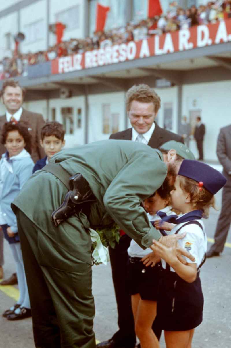 Zum feierlichen Empfang des Staats- und Parteivorsitzenden der DDR, Erich Honecker, auf dem Flughafen Santiago de Cuba küßt der kubanische Regierungschef Fidel Castro ein kleines Mädchen in Pionieruniform auf die Wange. Honecker stattete vom 2