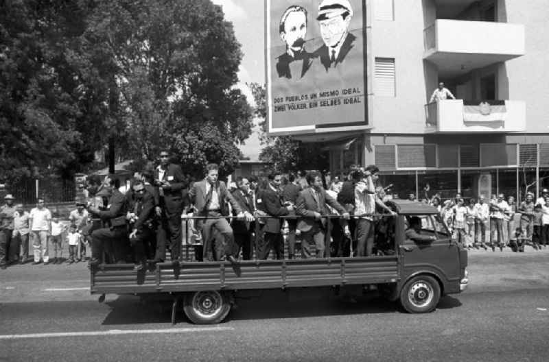 Mit großem Jubel wird in der kubanischen Bevölkerung die Ankunft des Staats- und Parteivorsitzenden der DDR, Erich Honecker, in Santiago de Cuba gefeiert - hier der Wagen mit Vertretern der Presse. Im Hintergrund ein Plakat mit den Gesichtern von José Martí und Erich Honecker mit der Aufschrift 'Dos pueblos un mismo ideal - Zwei Völker ein selbes Ideal'. Honecker stattete vom 2