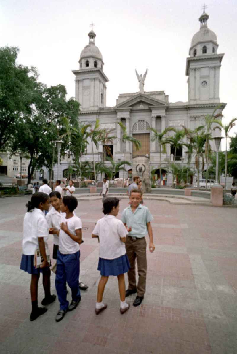 Kubanische Schüler in Schuluniform im Parque Céspedes vor der Kathedrale Santa Iglesia Catedral Metropolitana in der Altstadt von Santiago de Cuba.