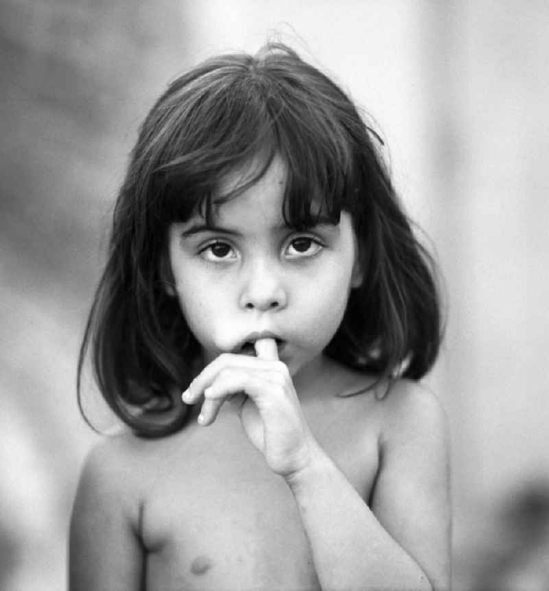 Porträt eines am Zeigefinger nuckelnden Mädchens in Santiago de Cuba.