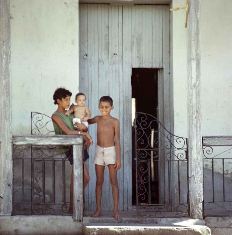 Familie vor ihrem Hauseingang in Santiago de Cuba.