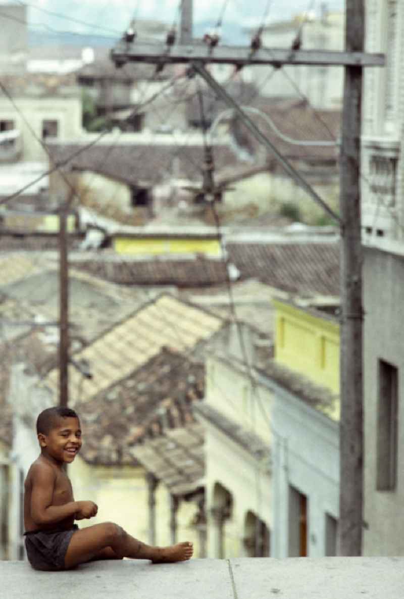 Ein Junge sitzt auf der obersten Stufe einer Treppe in Santiago de Cuba.