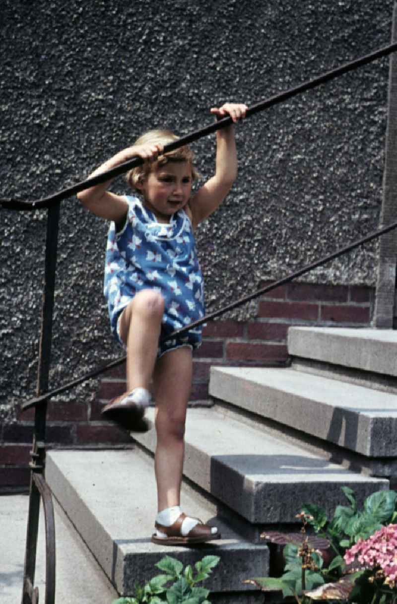 Mädchen klettert am Treppengeländer. Girl climbing on the banister.