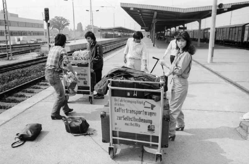 Vietnamese foreign workers by baggage car at the railway station airport Berlin-Schoenefeld in Schoenefeld in the federal state Brandenburg in the area of the former GDR, German democratic republic