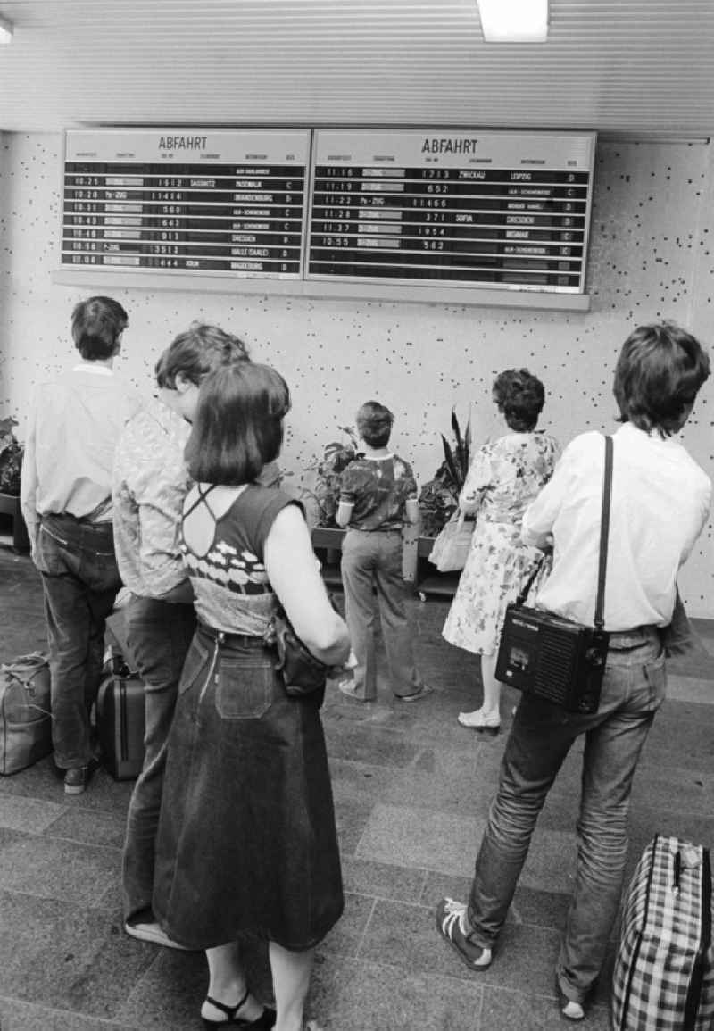 Passengers find out in the scoreboard about departure and arrival of the trains in the railway station airport Berlin-Schoenefeld  in Schoenefeld in the federal state Brandenburg in the area of the former GDR, German democratic republic